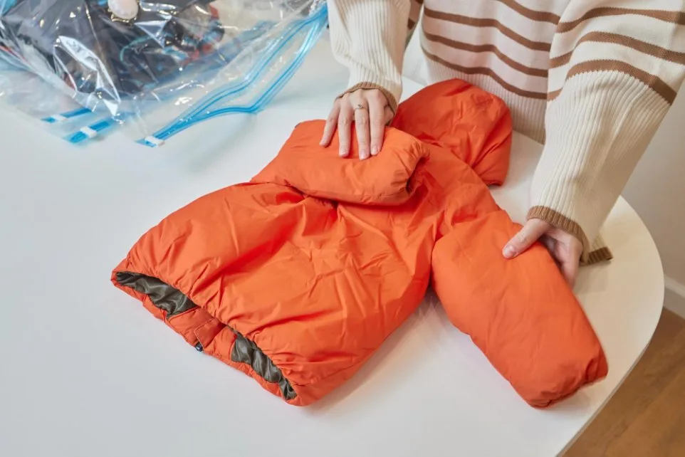 Hands preparing insulated jacket for cleaning and DWR maintenance