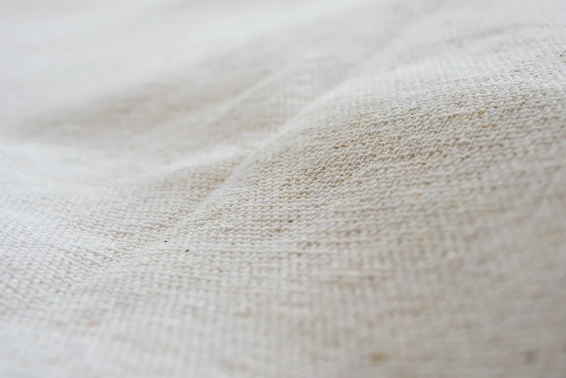 Various types of organic cotton fabrics displayed showing different weaves and textures suitable for baby clothing