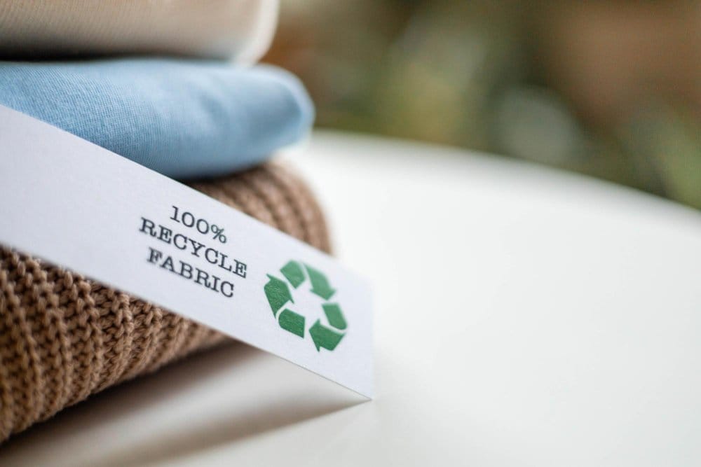 Recycled fabric label with green recycling symbol representing sustainable textiles