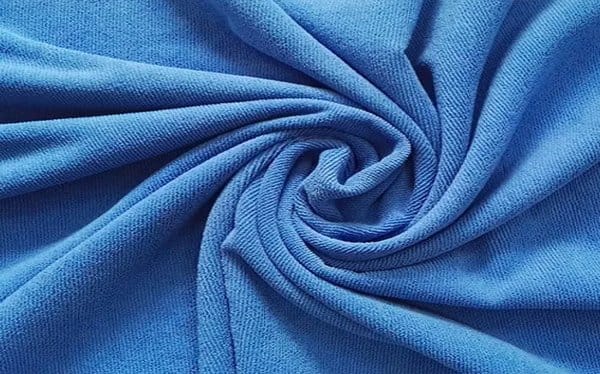 Blue stretch fabric twisted to show flexibility and moisture wicking properties