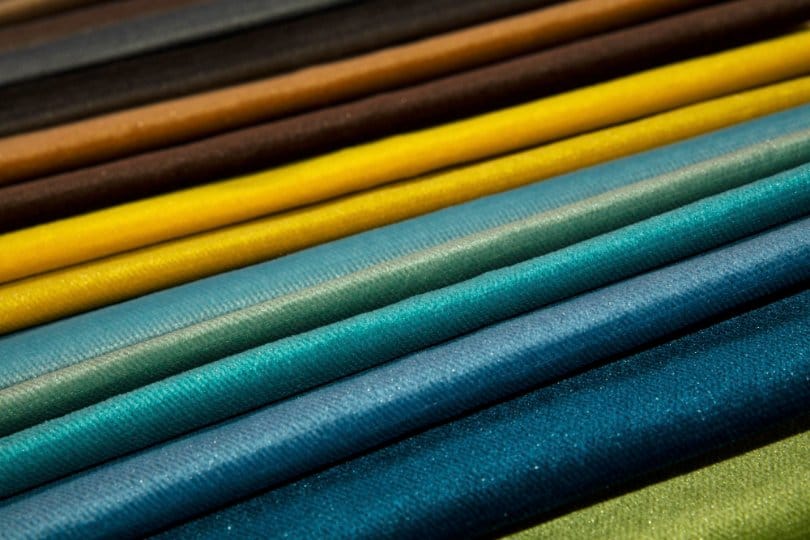 Colorful synthetic fabric rolls arranged in layers showing variety of textures