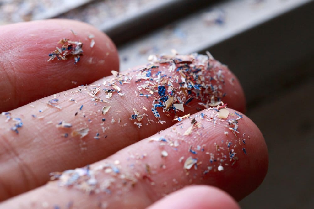 Tiny plastic microfibers collected on fingers illustrating microplastic pollution