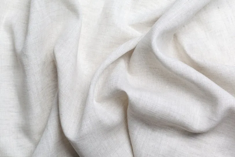 Close-up of soft white cotton fabric showing natural fiber texture and breathable open weave