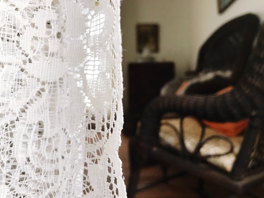 Elegant living room featuring knotted lace curtains as decorative window treatments