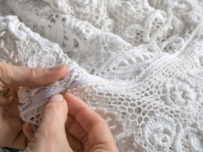 DIY knitted lace crafting setup with knitting needles, yarn, patterns, and work in progress