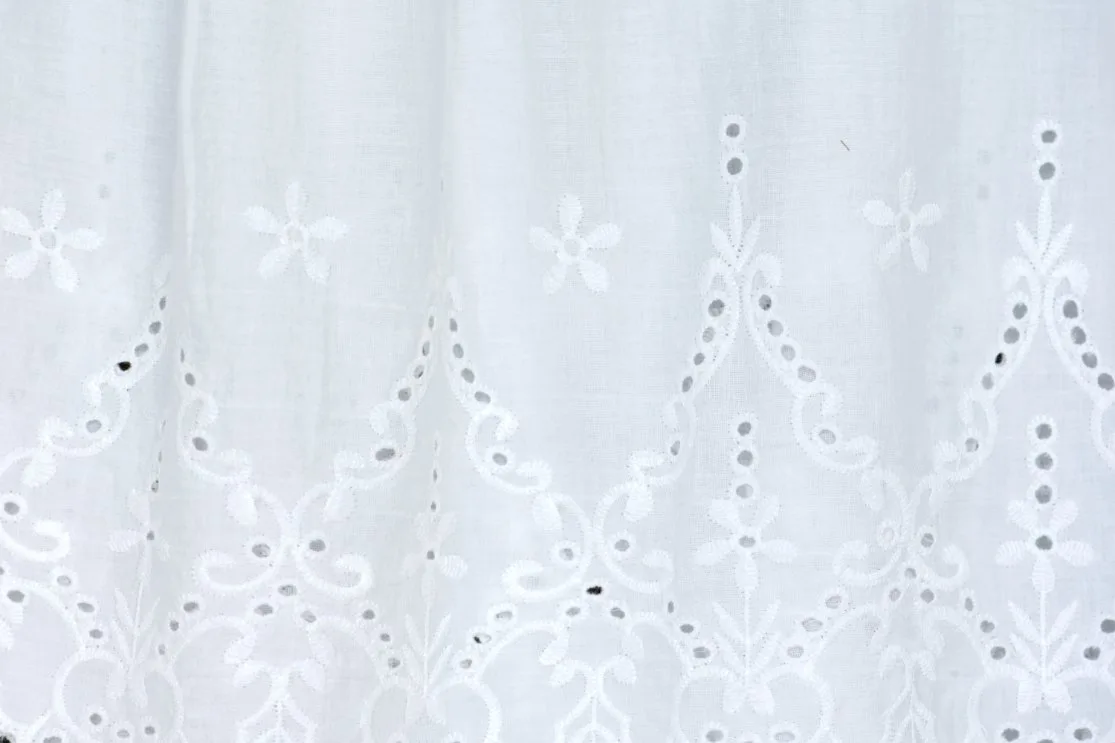 Examples of eyelet lace fabric showing decorative holes and embroidered patterns