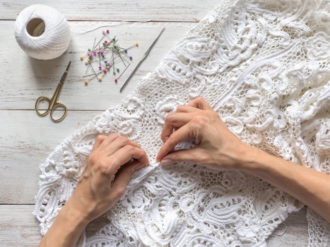 Close-up of knitted lace fabric showing intricate openwork patterns and stretch properties