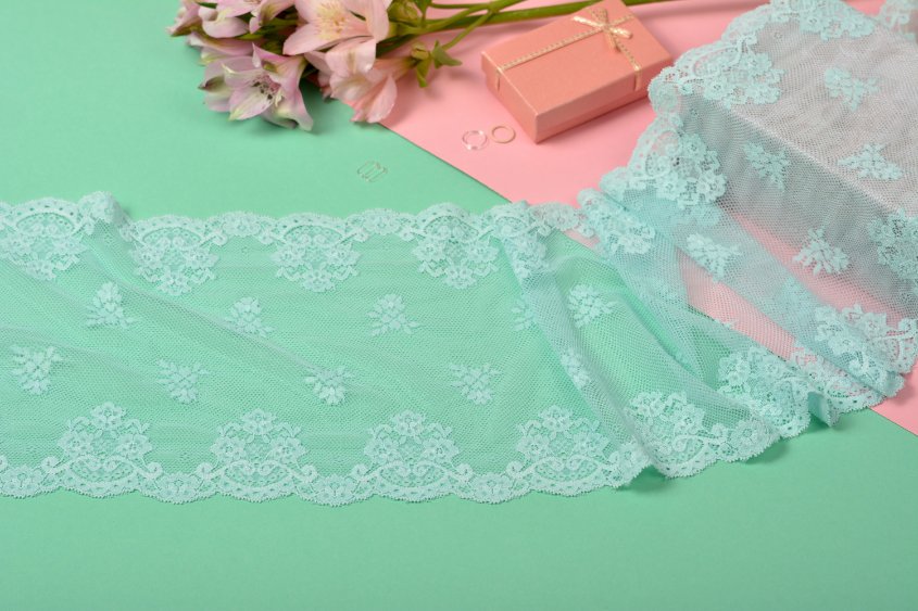Various types of ribbon lace fabric displayed showing different patterns and widths