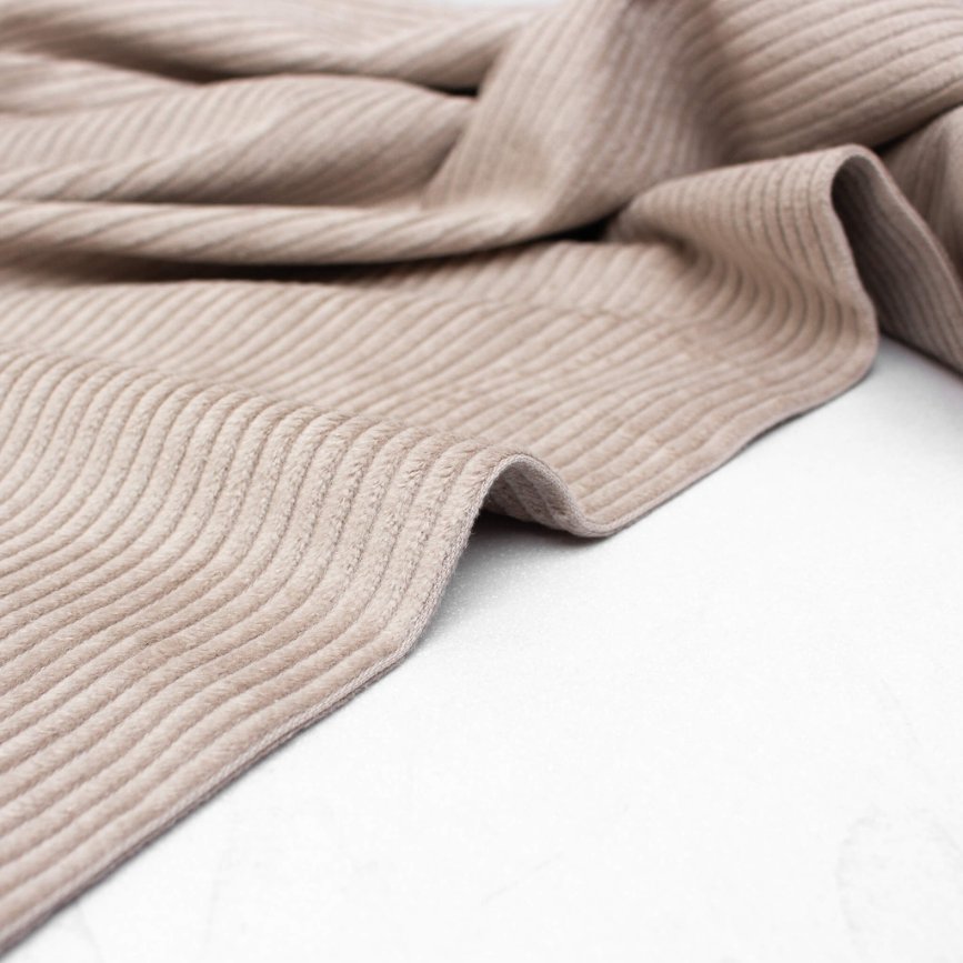 Demonstration of corduroy's unique properties including warmth, durability, and texture