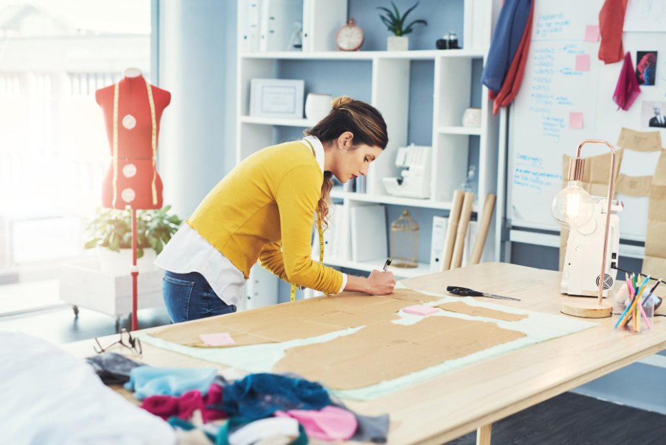 Well-organized sewing workspace with machine, cutting area, storage solutions, and good lighting