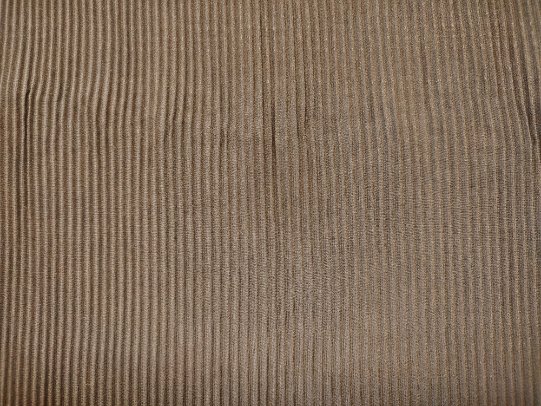 Brown corduroy fabric showing vertical ridges.