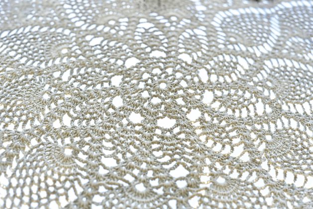 Close-up of intricate crochet lace with floral motifs.