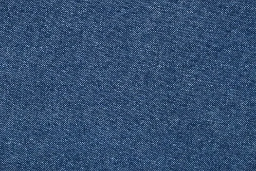 Close-up view of denim fabric showing the characteristic twill weave pattern and indigo-dyed cotton fibers