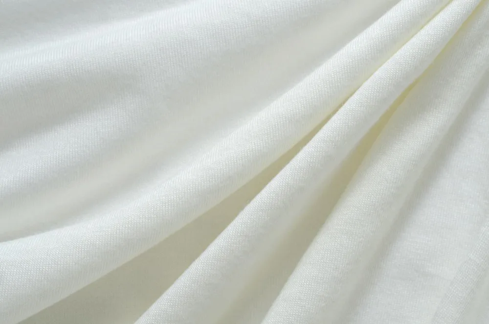 White Egyptian cotton fabric folded in soft layers.