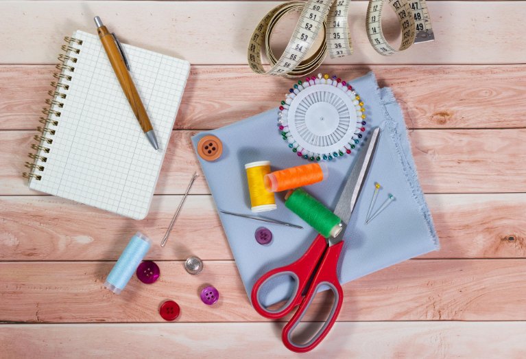 Sewing foundation essentials including fabric, scissors, thread, and sewing machine setup