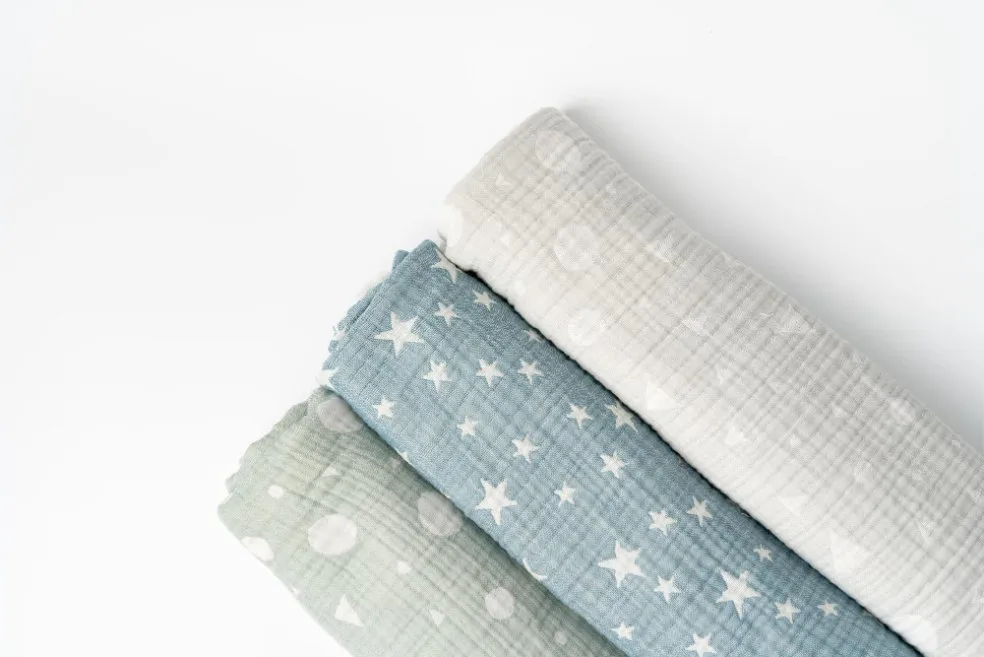 Rolled muslin cotton fabrics with star and dot patterns.