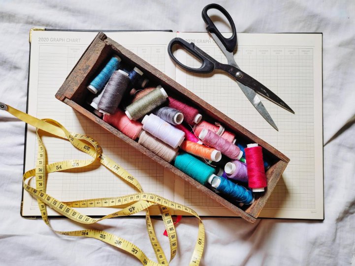 Essential tools for bound seam finishing including bias tape, scissors, pins, and presser feet