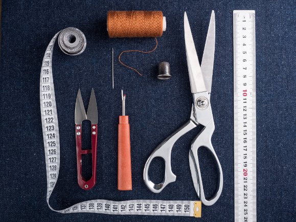 Essential tools for sewing French seams including scissors, iron, and measuring tools