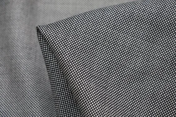 Detailed view of folded black and white Bird’s Eye fabric showing its fine diamond pattern.