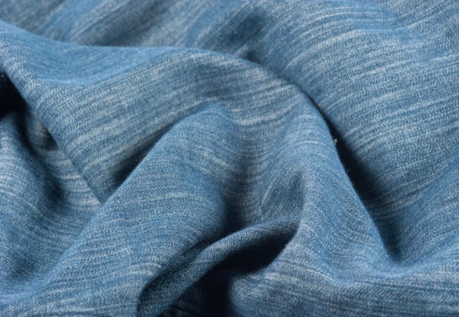 Close-up of denim fabric with soft texture in blue.