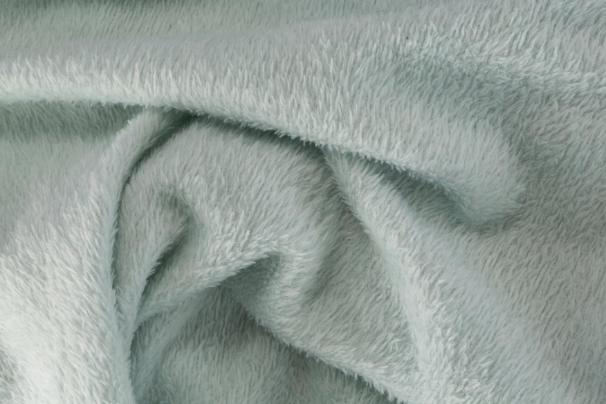 Close-up of soft grey fleece fabric with a textured, warm surface.