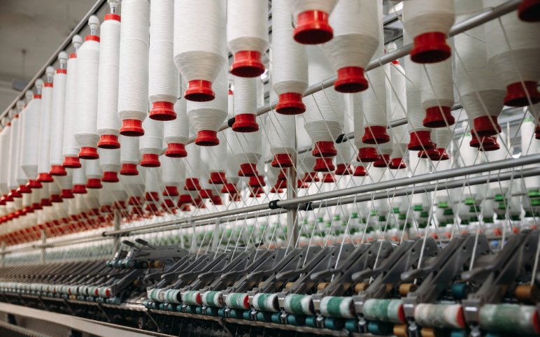 Manufacturing process diagram showing how spun polyester is made from fiber preparation to final fabric