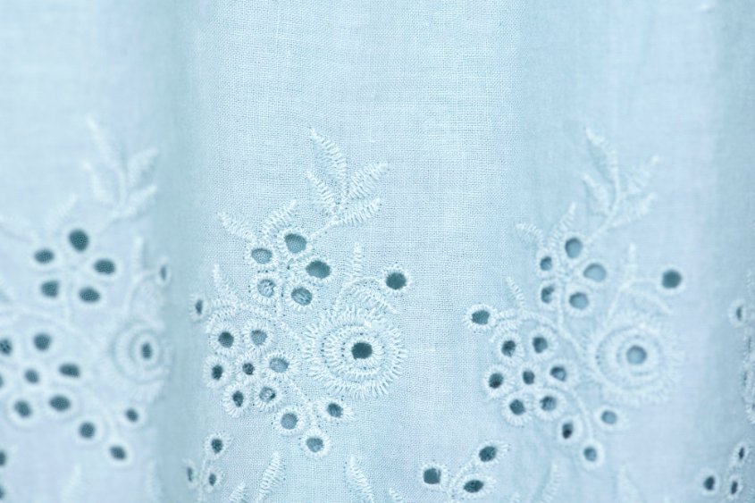 Guide to selecting quality broderie anglaise fabric showing different textures and quality indicators