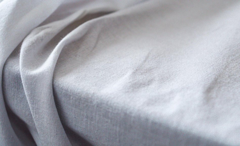 White cotton fabric draped over a surface with soft fall.
