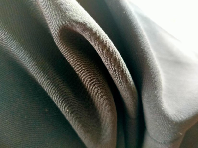 Close-up of black recycled polyester (rPET) fabric showing smooth weave and texture.