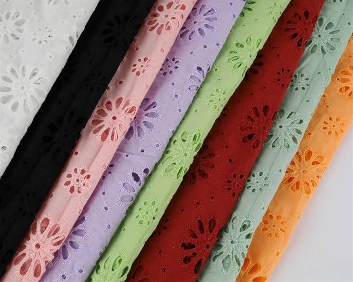 Different types and variations of broderie anglaise cotton fabric showing various patterns and colors