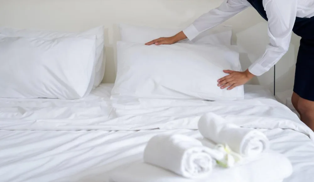Luxury hotel bed made with high-quality white linen sheets and bedding