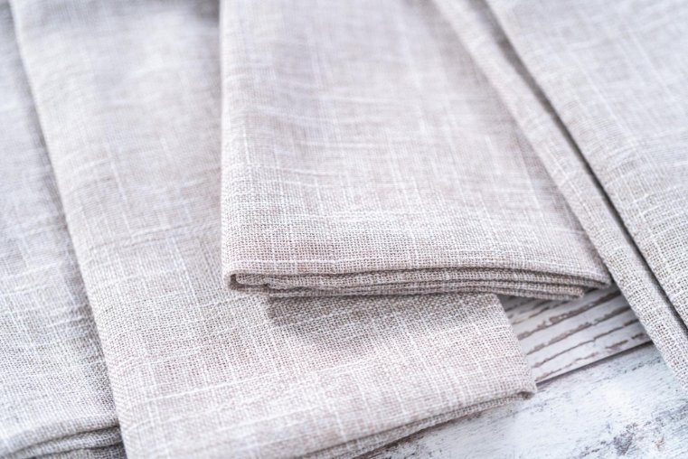 Close-up of natural butcher’s linen fabric showing crisp weave and durable texture.