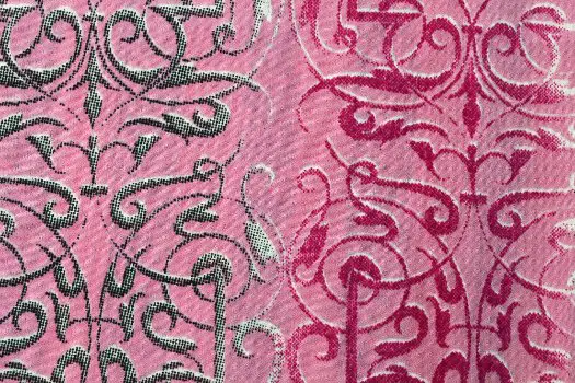 Historic brocade fabric featuring ornate woven patterns in contrasting pink and black tones