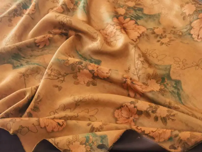 Floral printed Canton silk fabric in warm tones with soft draping folds
