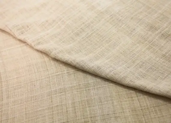 Close up of natural beige Eri silk fabric showing its soft texture and matte finish