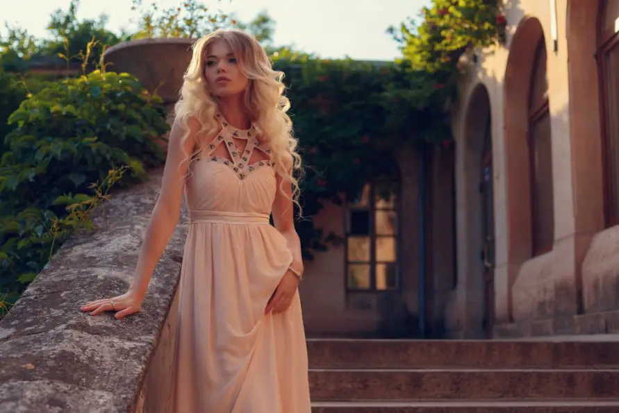 Woman wearing a peach georgette gown posing outdoors to showcase the fabric's drape and elegance