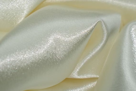 Close-up of ivory Japanese crepe back satin with a soft sheen and smooth drape