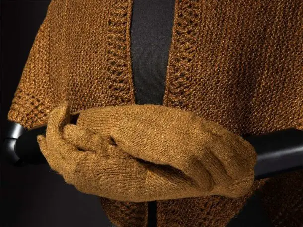 Golden brown sea silk shawl and gloves displayed on a mannequin to show the natural luster of byssus fiber