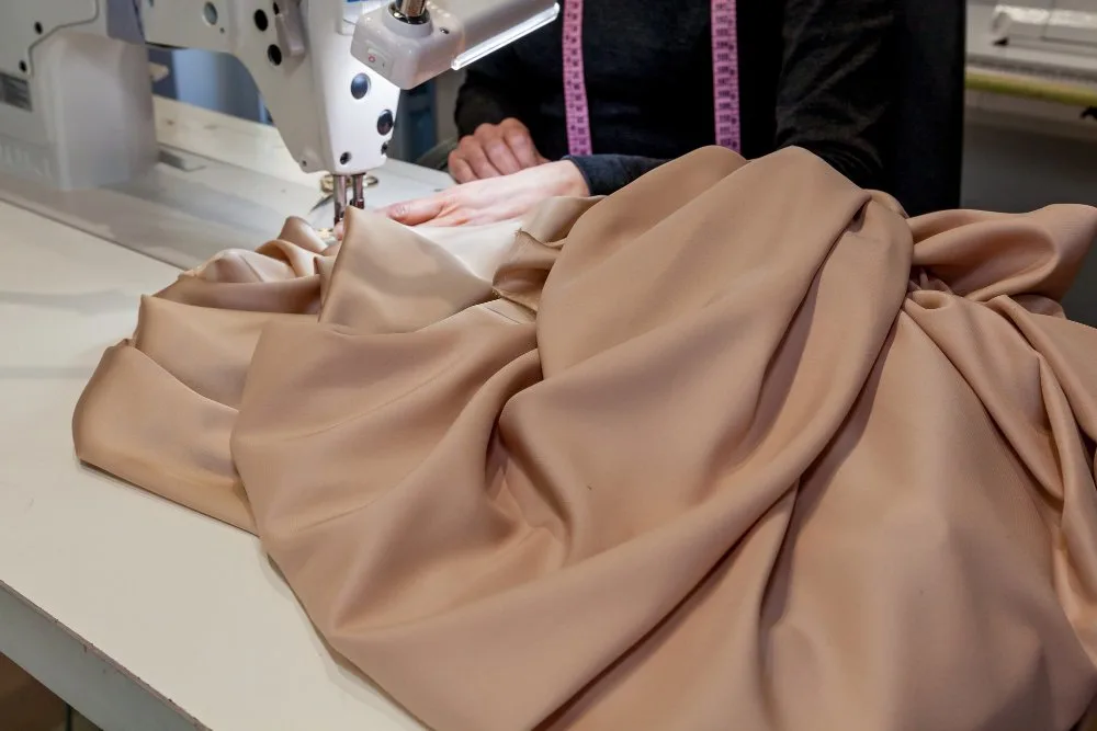 Dressmaker sewing Dupioni silk fabric on a sewing machine