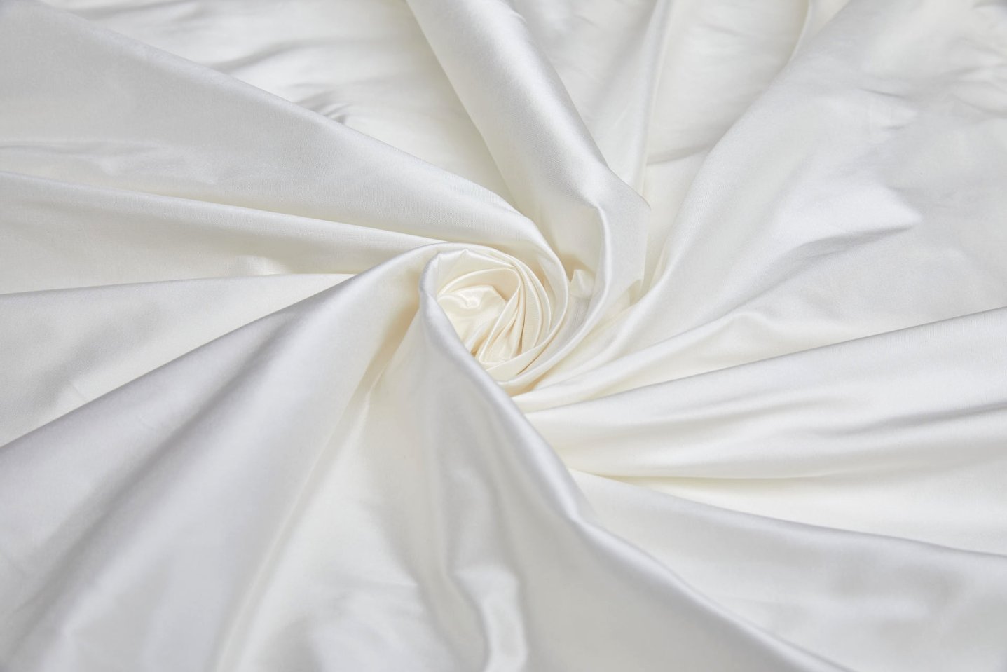 Luxurious white silk taffeta fabric arranged in elegant folds with a natural sheen