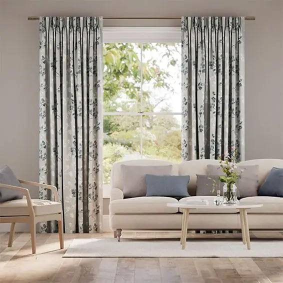 Living room with floral art silk curtains, beige sofa, accent pillows, and wooden furniture
