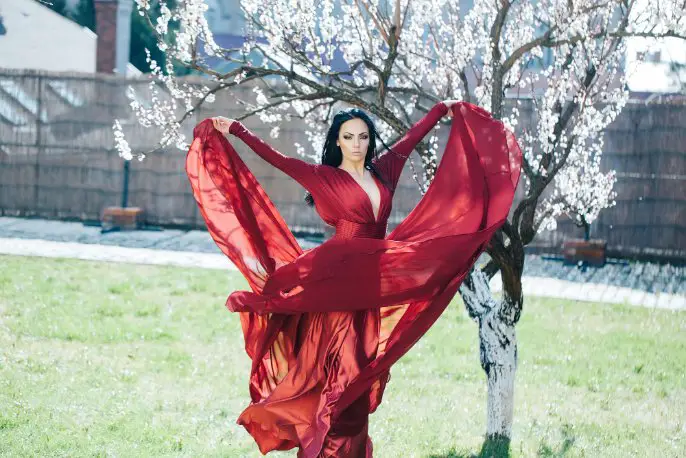 Woman wearing a flowing red gown outdoors showing the fluid drape of lightweight silk or Crepe de Chine fabric