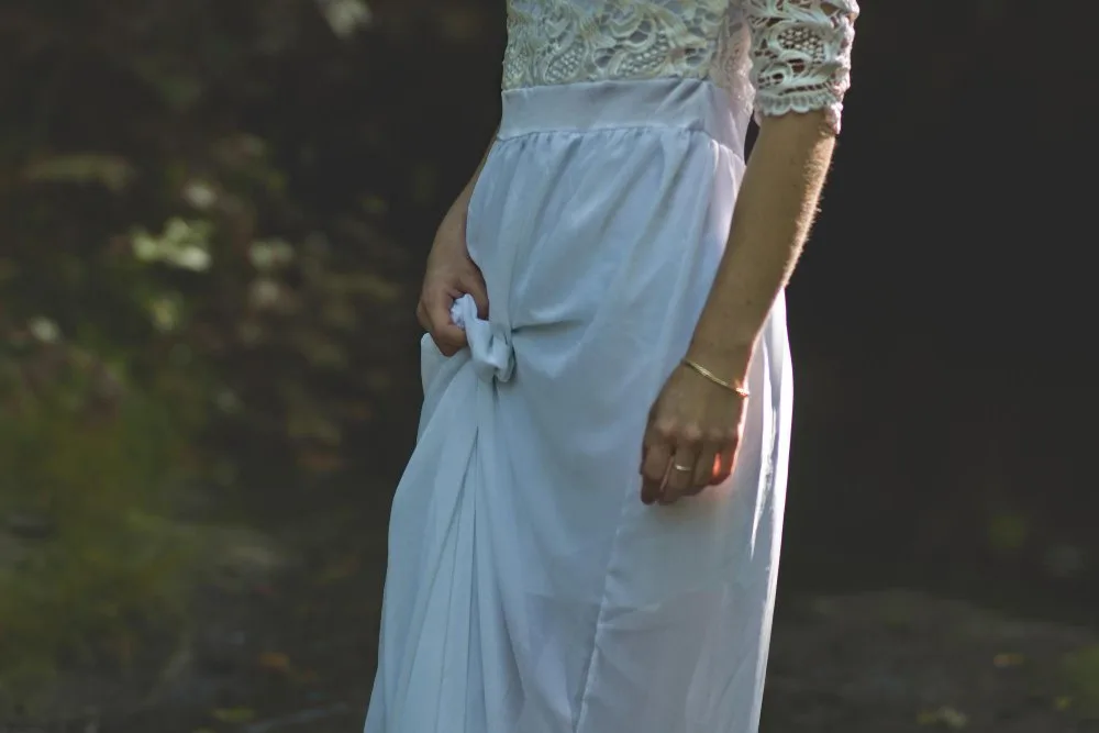 Woman wearing a white Dupioni silk dress in a natural outdoor setting