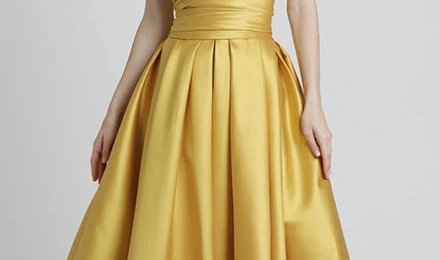 Gold taffeta dress with a fitted bodice and a full pleated skirt showing the fabric's structured drape