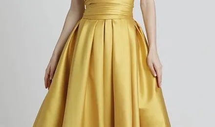 Gold taffeta dress with a fitted bodice and a full pleated skirt showing the fabric's structured drape