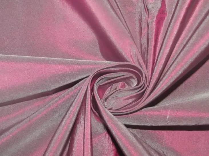 Pink taffeta fabric with a swirling fold showing sheen and crisp texture