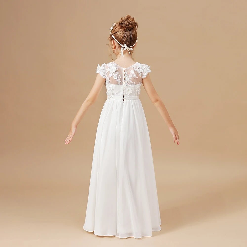 Junior bridesmaid wearing a white lace and chiffon floor length dress with a sheer floral back detail
