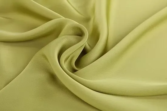 Light green acetate chiffon fabric arranged in soft twists showing its airy and semi translucent texture
