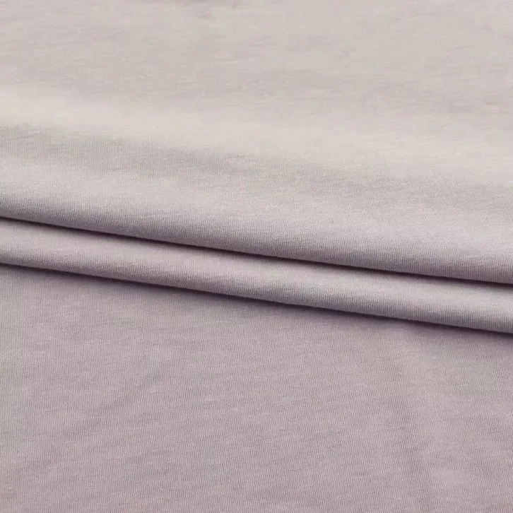 Folded acetate jersey fabric in a soft lavender tone showing its stretch and smooth knit surface