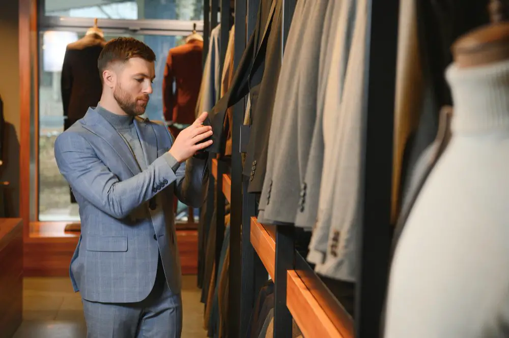 Man examining wool suits in a clothing store
